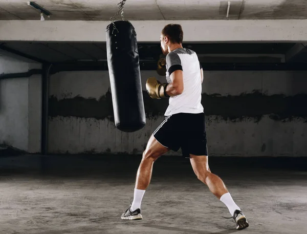 年轻的肌肉拳击手在体育馆里用拳击袋 拳打脚踢速度袋 — 图库照片
