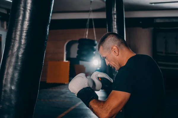 暗い背景にフィットネスジムで若い男運動選手ボクシングのトレーニング ハード運動選手のトレーニング キックボクシングの概念 — ストック写真