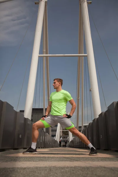 强壮有力的家伙把腿伸到桥中央 — 图库照片