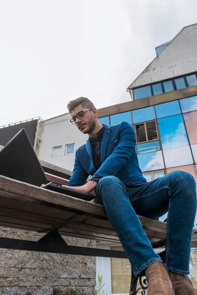 Stilvoller Mann Sitzt Auf Bank Stadtplatz Und Schaut Laptop — Stockfoto