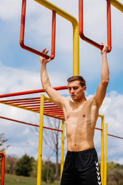 Sportlicher Junger Mann Hängt Lächelnd Der Stange Der Calisthenics Turnhalle — Stockfoto