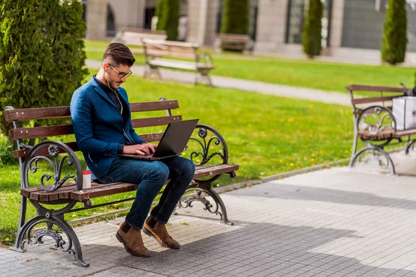 Stilvoller Mann Sitzt Auf Bank Stadtplatz Und Schaut Laptop — Stockfoto