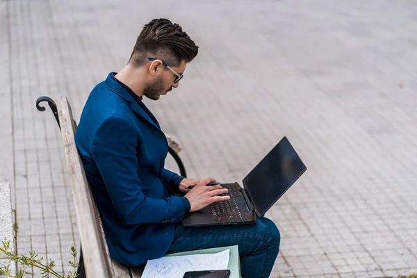 Takdire Şayan Adamı Şehir Meydanında Oturuyor Dizüstü Bilgisayarla Çalışıyor — Stok fotoğraf