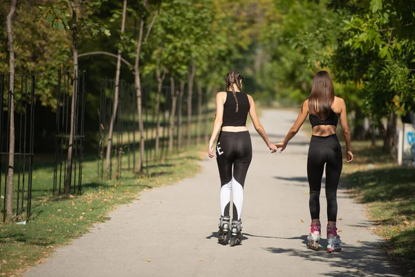 Beautiful Sweet Girlfriends Riding Roller Skates Holding Hands Street — Stock Photo, Image