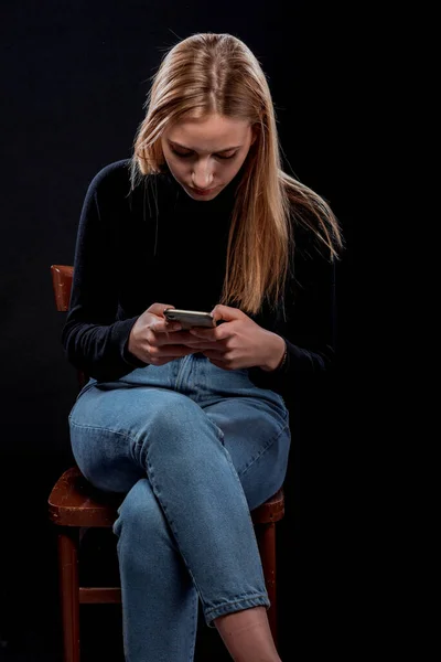Приваблива Молода Жіноча Модель Використанням Смартфона Позуючи Чорному Тлі — стокове фото