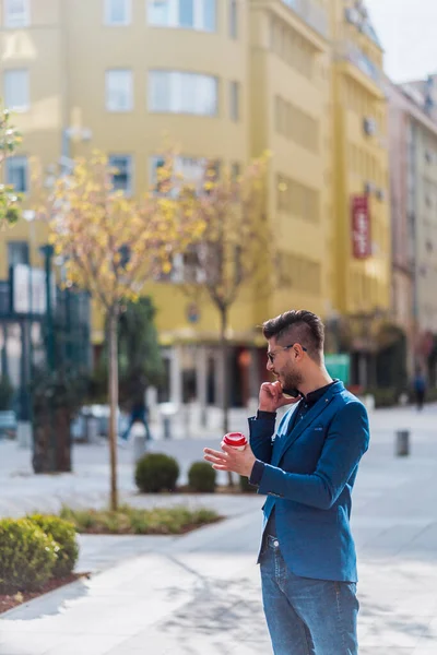 一个自信的年轻商人在城市里用手机交谈时的全长肖像 — 图库照片