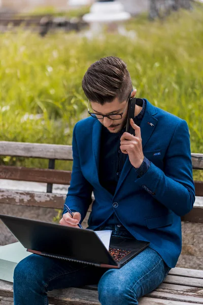 Stilvoller Mann Gelbem Mantel Bedient Laptop Und Handy Gleichzeitig — Stockfoto