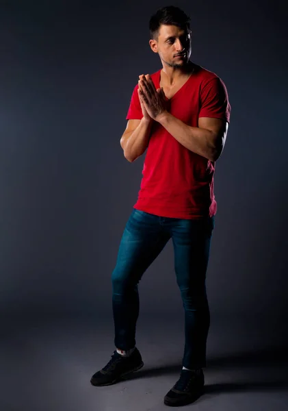 Kırmızı Tişört Mavi Kot Giyen Havalı Genç Adam Karanlık Stüdyoda — Stok fotoğraf