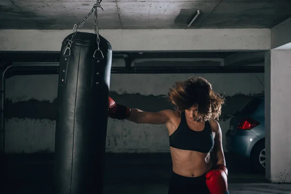 Visão Perfil Uma Jovem Forte Perfurando Saco Boxe Dentro Garagem — Fotografia de Stock