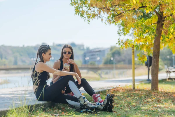Deux Filles Assoient Dans Parc Tout Prenant Une Pause Patinage — Photo