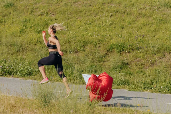 Vista Lateral Una Joven Fitness Corriendo Usando Paracaídas Resistencia Roja —  Fotos de Stock