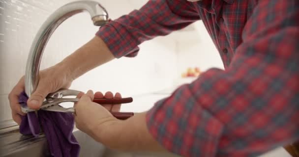 台所の蛇口の状態を検査する古い配管工 — ストック動画
