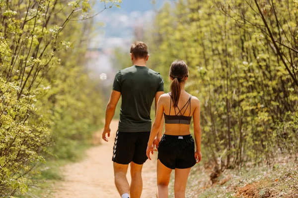 男人和女人在公园里一起运动和慢跑 在一个温暖的夏日 当他们在夕阳西下沿着小路奔跑时 他们又快乐又笑 — 图库照片