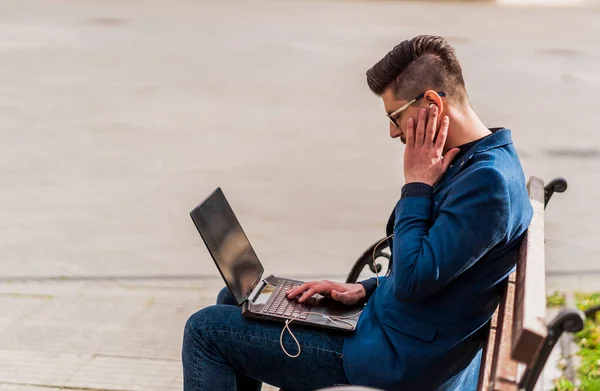 Junger Mann Sitzt Auf Holzbank Park Und Blättert Seinem Laptop — Stockfoto