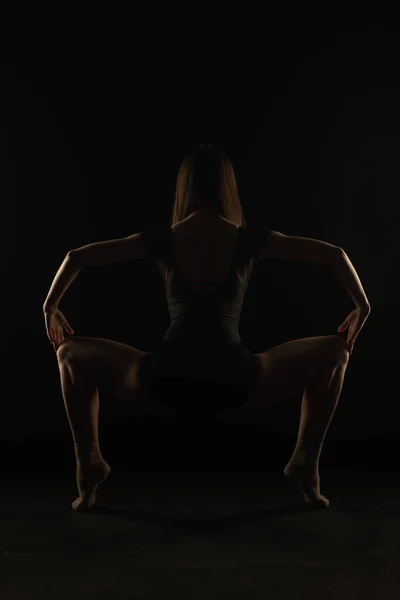 Bailarina Está Segurando Uma Postura Agachamento Agradável Das Costas Silhueta — Fotografia de Stock