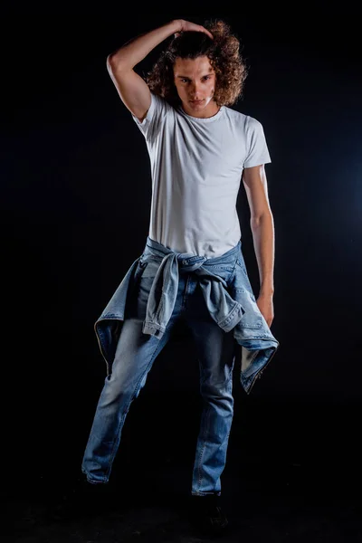Pria Trendi Tampan Berkaos Mengenakan Jeans Bergaya Terisolasi Dinding Hitam — Stok Foto