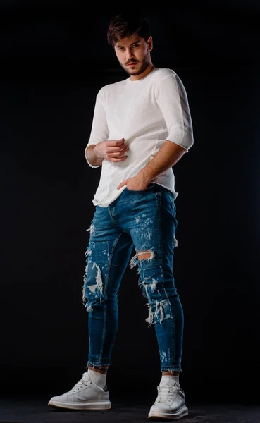 Atractivo Joven Elegante Hombre Posando Pantalones Vaqueros Rasgados Jersey Blanco — Foto de Stock