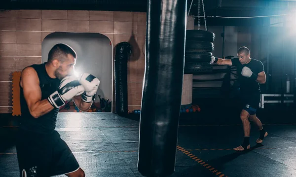 Junger Muskelboxer Mit Boxsack Fitnessstudio Boxer Prallt Gegen Boxsack — Stockfoto