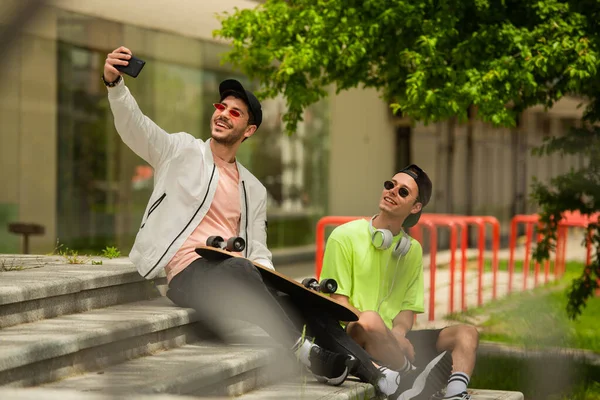 Two handsome guys friends are smiling for the selfie they are taking