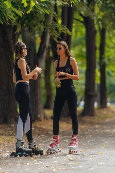 天気の良い日に公園でスポーツウェアローラーブレードの2人の女性 — ストック写真