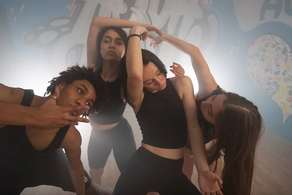 Young group of multiracial friends dancing enjoying and dancing together while improvising dance moves