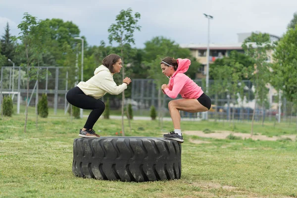 Flicka Squtting Medan Den Andra Hoppar Huk Bulldozer Däcket — Stockfoto