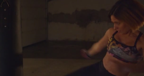 强壮的女孩正在打拳袋上练习踢腿 — 图库视频影像