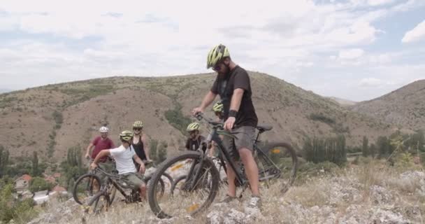 Grupo Amigos Estão Fazendo Uma Pausa Ciclismo Colina Acima — Vídeo de Stock