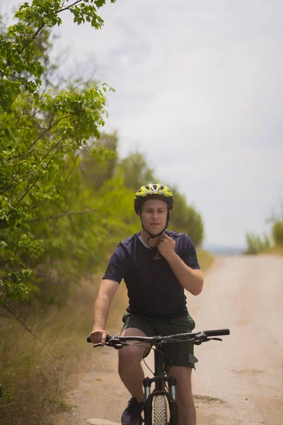 英俊金发男人骑自行车时带着头盔的画像 — 图库照片