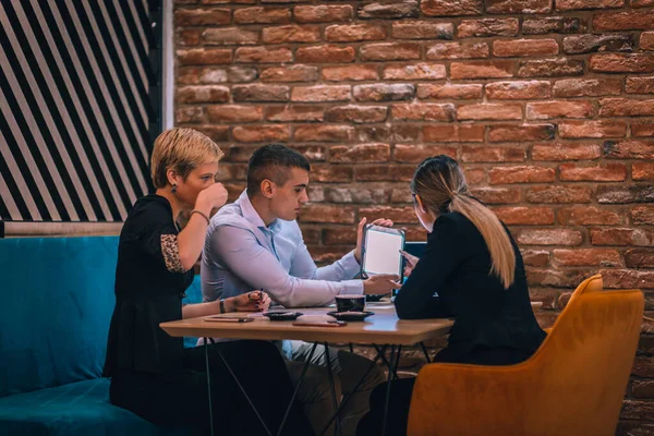 Grupa Trzech Osób Laptopem Tabletem Pracujących Nad Projektem Kawiarni — Zdjęcie stockowe