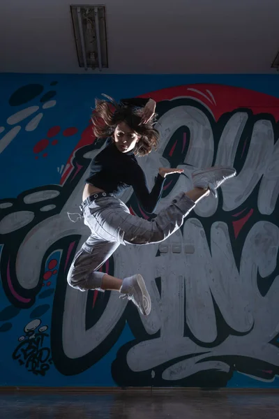 落書きスタジオの背景で踊る若い女性ヒップホップダンサー ブレイクダンサー のシルエット コントラストカラー — ストック写真