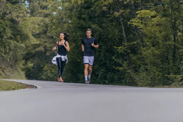 一对运动型的夫妇在一条街上跑着 彼此相邻 健康和健康的概念 — 图库照片
