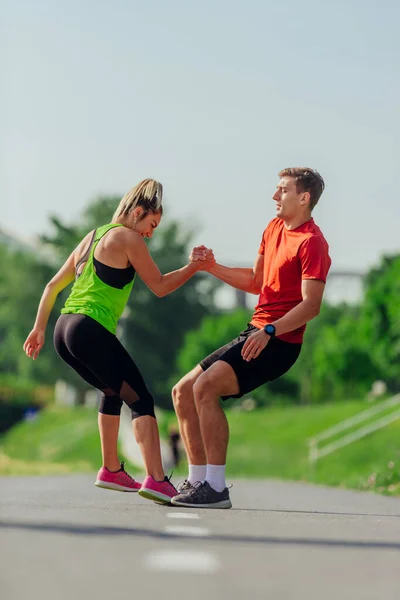 Aantrekkelijke Vrouw Helpt Haar Mannelijke Running Partner Staan Van Het — Stockfoto