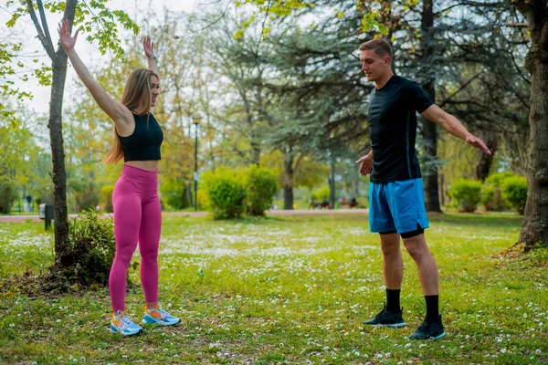 Casal Alongamento Músculos Grama Verde Parque Atleta Faz Exercícios Livre — Fotografia de Stock