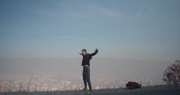 爆発物の準備をしてる男は朝山を駆け上がる — ストック動画