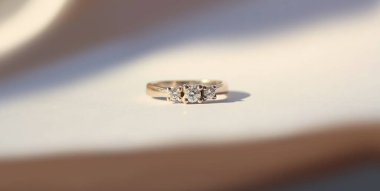 Beyaz arkaplanda küçük elmaslarla güzel altın bir yüzük..