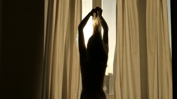 Женщина просыпается, силуэт женщины у окна — стоковое видео