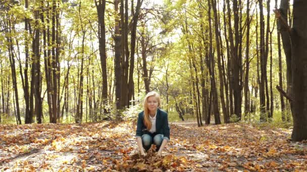 Mädchen wirft Blätter im Herbst in Zeitlupe — Stockvideo