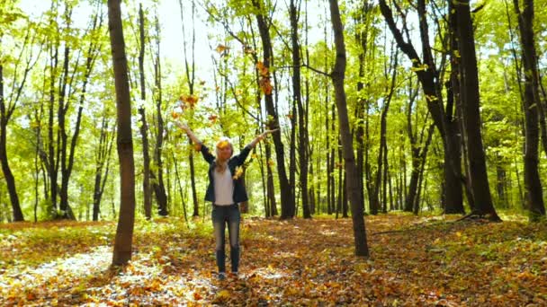 Chica lanzando hojas en otoño en cámara lenta — Vídeo de stock