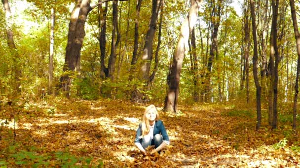 Κορίτσι που ρίχνουν τα φύλλα το φθινόπωρο σε αργή κίνηση — Αρχείο Βίντεο