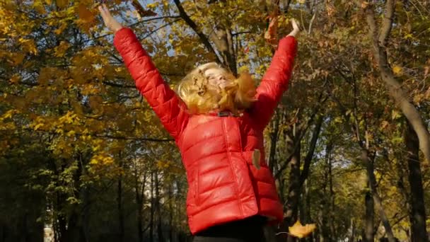 Chica lanzando hojas en otoño en cámara lenta — Vídeos de Stock