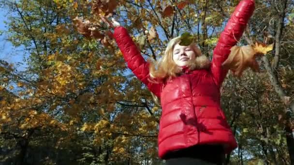 Chica lanzando hojas en otoño en cámara lenta — Vídeos de Stock