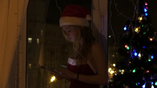 Blondynka w santa hat z tabletem — Wideo stockowe