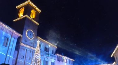Mombaroccio 'nun ana meydanında Noel zamanı, Marche bölgesinde yapay kar yağışı