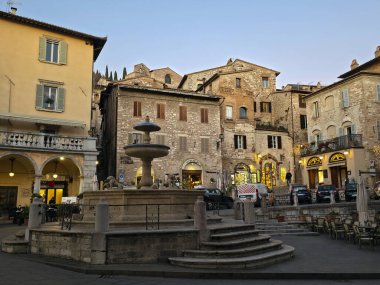 ASSISI, ITALY - 10 Aralık 2025: Assisi, İtalya 'da Piazza del Comune' un tarihi taş binalar, 