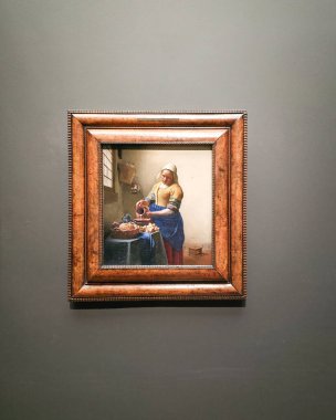 AMSTERDAM, NETHERLANDS - 11 HAZİRAN 2026: Vermeer 'in Rijksmuseum' daki Sütçü Kızı süt döken bir mutfak hizmetçisini resmediyor, zarif ışık ve dokuma ile yakalanmış basit bir ev kadını.