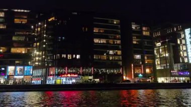 AMSTERDAM, NETHERLANDS 10 HAZİRAN 2026 Amsterdam kanallarında büyüleyici bir gece gezisi. Aydınlatılmış köprüler ve suya yansıyan tarihi evler. Hollanda 'nın göbeğinde romantik şehir ışıkları ve tekne turu
