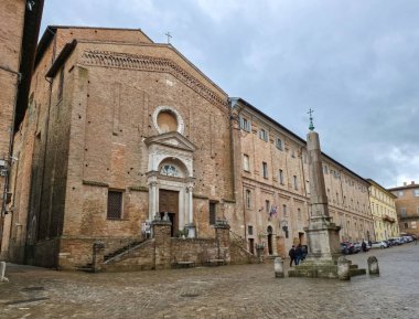 URBINO, İtalya - 28 Ocak 2026: San Domenico Kilisesi 'nin Gotik Cephesi ve Piazza Rinascimento, İtalya' daki Antik Mısır Obelisk