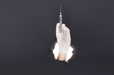 Mavi kağıt arka plan ile kırma ve şırınga tutarak erkek el