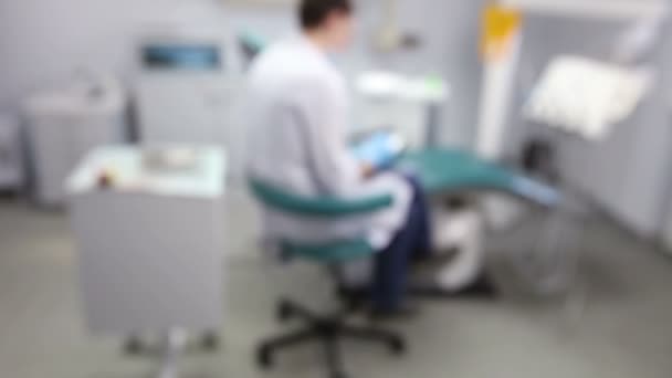 Oficina de dentistas. Doctor sentado cerca de la silla del dentista — Vídeos de Stock